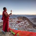 Buddhist monk with prayer wheel, Ganden monastery, Tibet